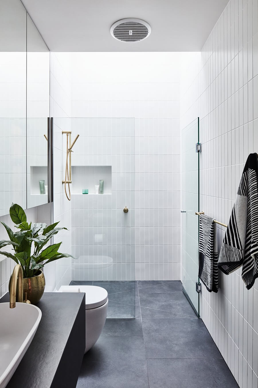 Un baño con mampara de ducha basculante, que se abre hacia fuera o hacia adentro de la ducha.
