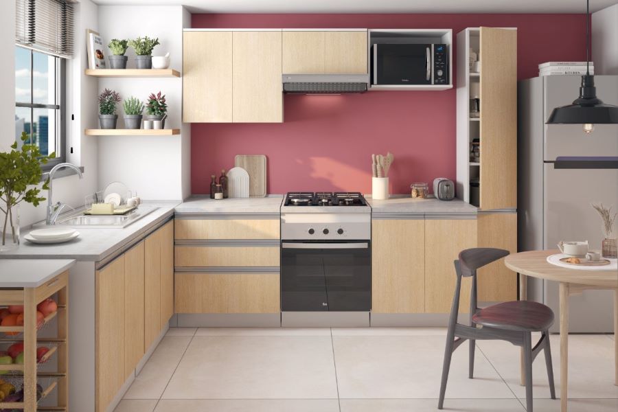 Amplia cocina moderna con muebles de madera y muro color rosa oscuro. Piso de cerámico beige y repisas flotantes de madera