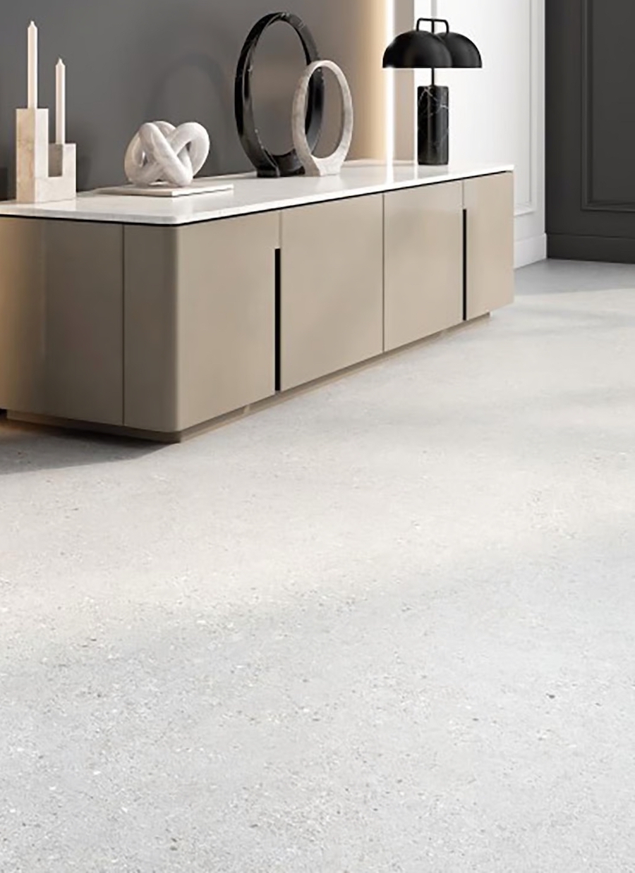 Sala con piso de porcelanato color gris. Arrimo con puertas beige, de estilo moderno. Sobre él hay varios adornos escultóricos, de estilo moderno.