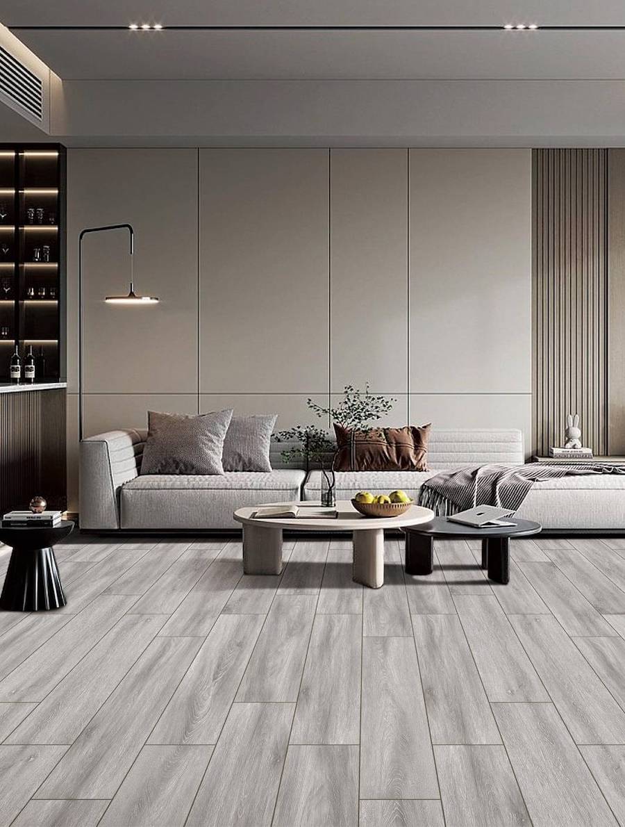 Sala de estar con piso de porcelanato imitación madera en tonos grises. Hay un gran sofá greige, 2 mesas de centro, una beige y la otra negra.