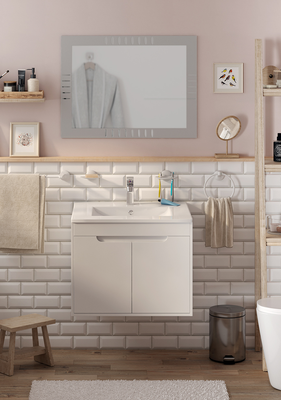 Baño de muros rosado pastel con cerámicas blancas en la parte inferior. Hay un espejo rectangular, un vanitorio blanco, repisas de madera y un WC blanco.
