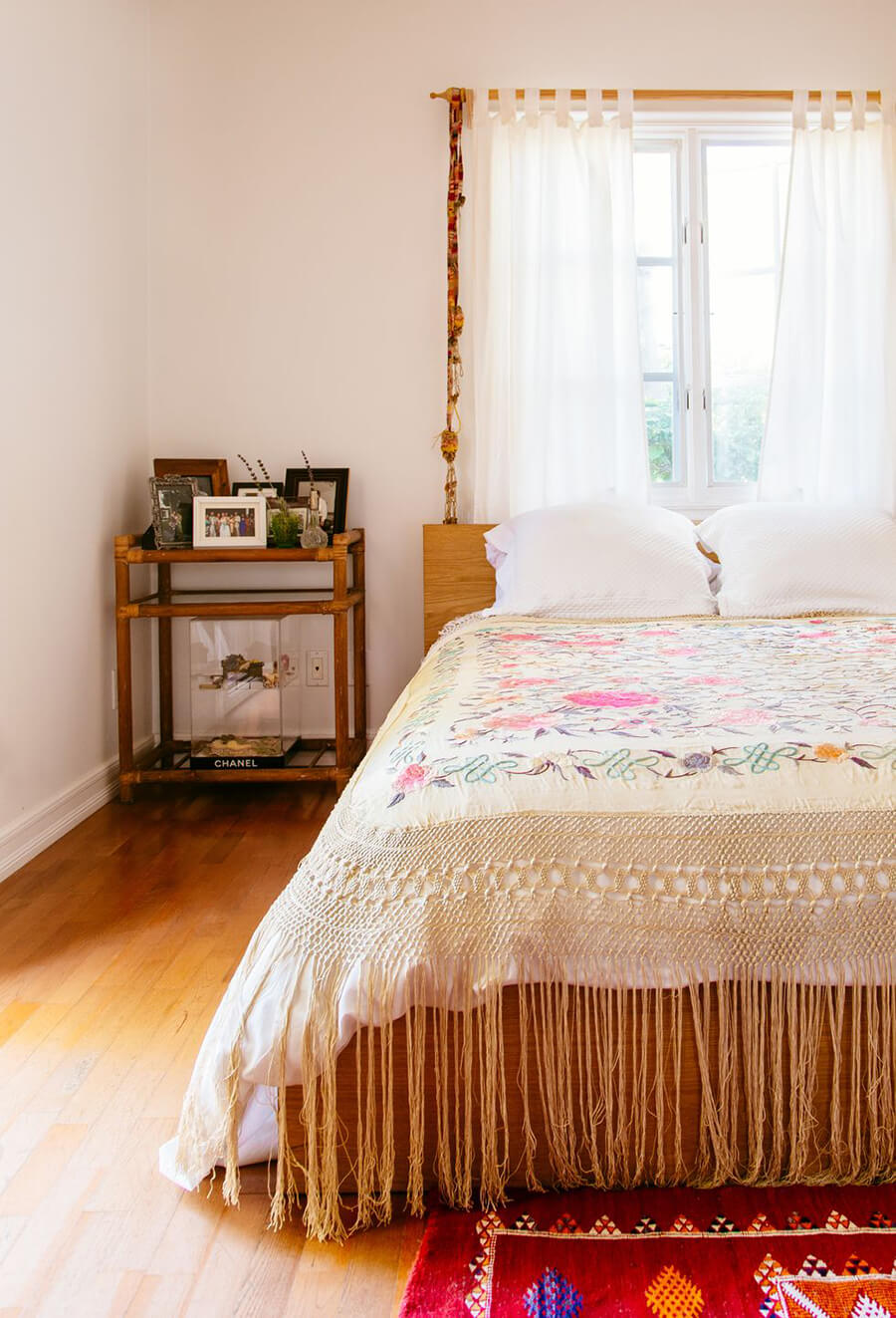 cama en dormitorio de colores claros con cobertor tipo mantón de manila