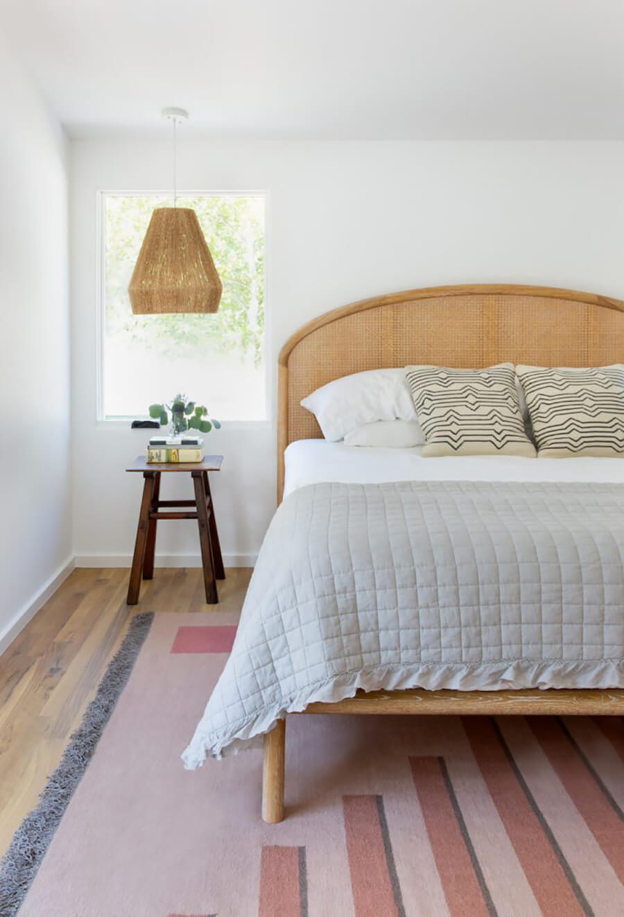 Un dormitorio moderno con una cama con respaldo de bambú 