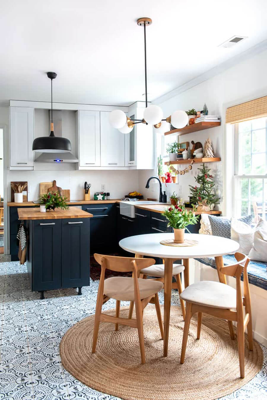 Una cocina abierta que se fusiona con el living, con muebles de cocina negros con cubierta de madera