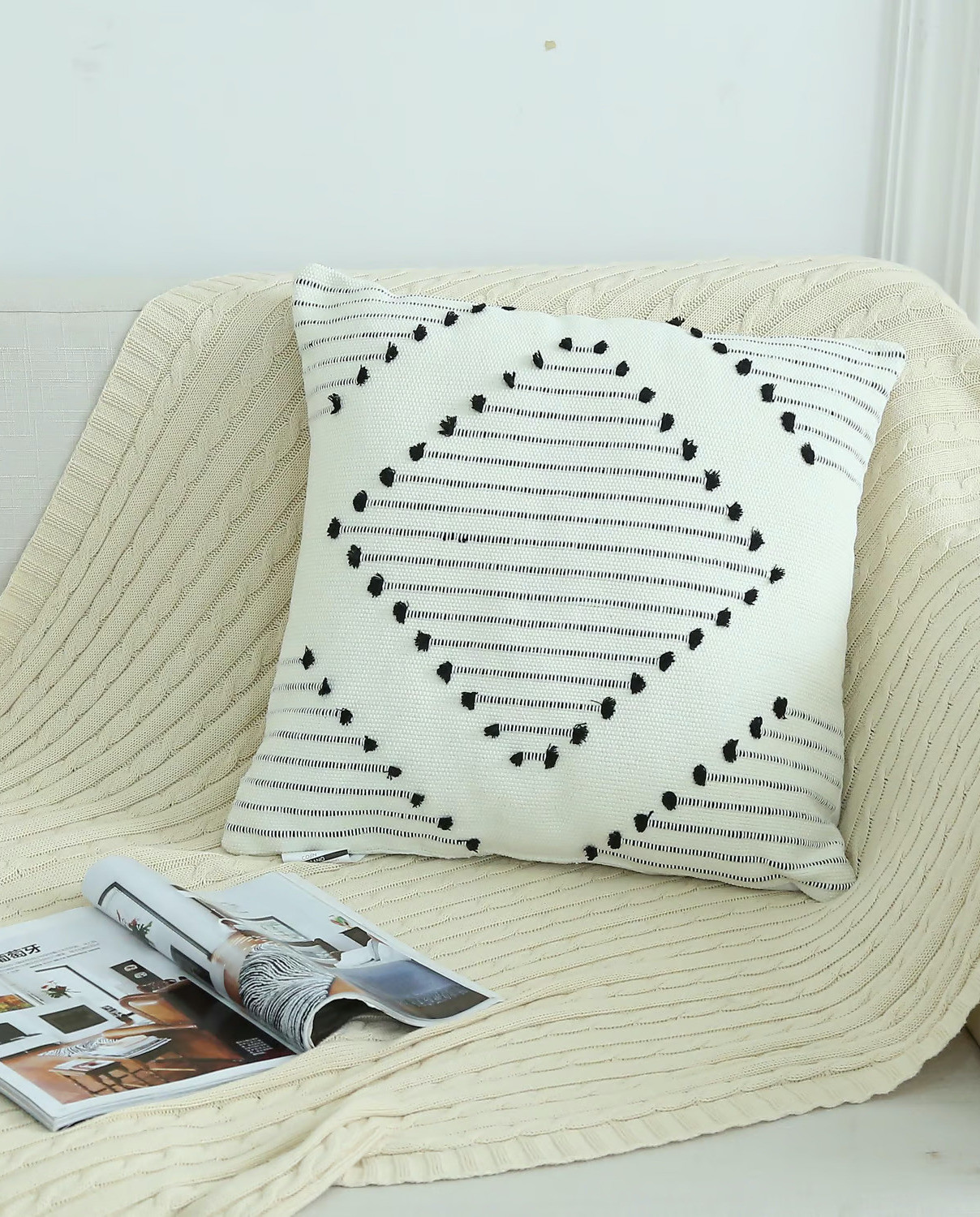 Manta beige con cojín con diseño boho, colo blanco y negro.