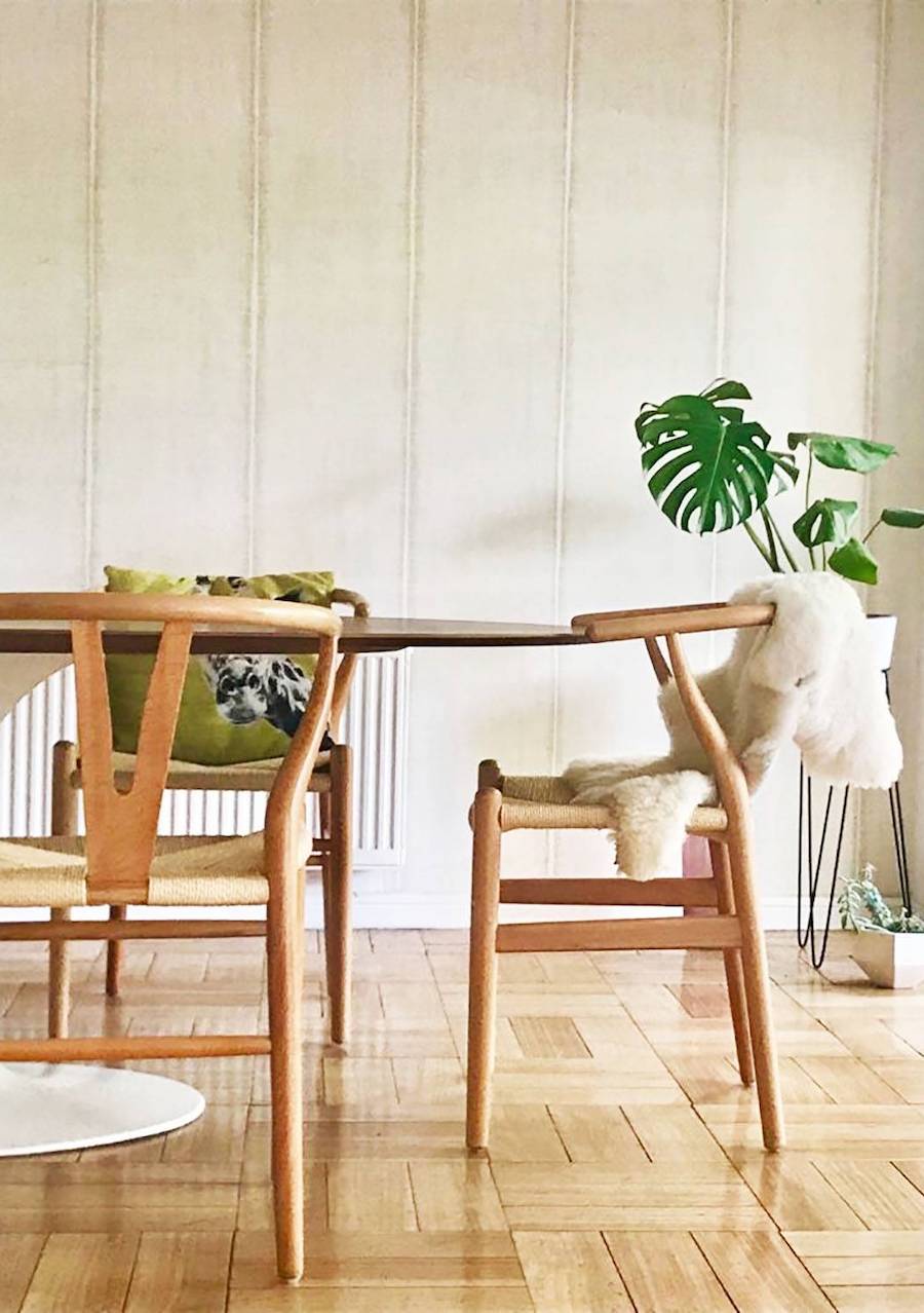 Comedor de paredes blancas y piso de madera, la mesa y las sillas son de madera.