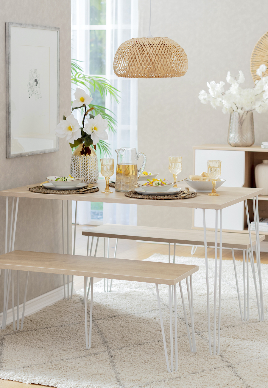 Comedor estilo nórdico con mesa de madera y patas de fierro con banquetas a juego. Lámpara colgante de ratán, estilo boho