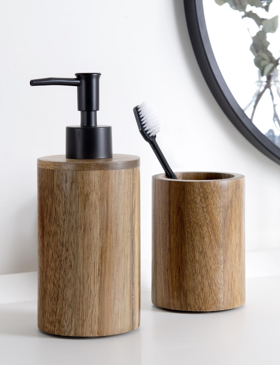 Accesorios en un baño rústico moderno. Jabonera y vaso de madera con un cepillo de dientes negro. 