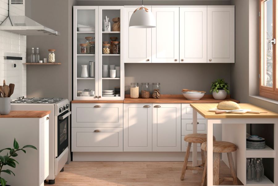 Cocina pequeña con paredes color gris, muebles de madera blancos, repisas flotantes y mesa de comedor con dos pisos.