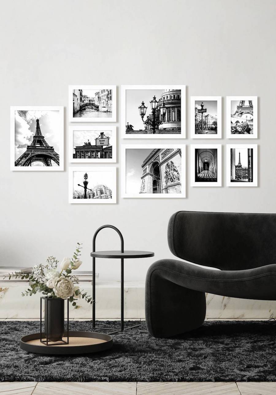 Sala de estar con un muro galería con fotos en blanco y negro y marcos blancos.