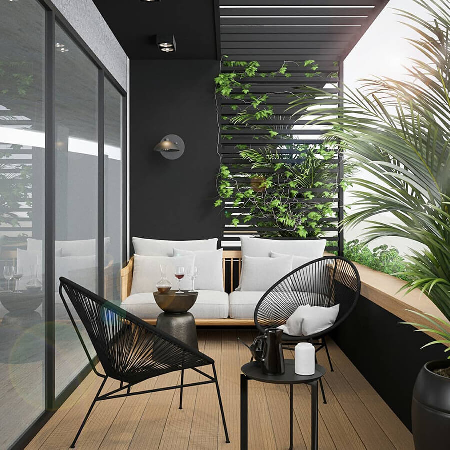 Balcón moderno con piso de madera, un sillón de terraza blanco y dos asientos con cojines. Alrededor hay plantas.