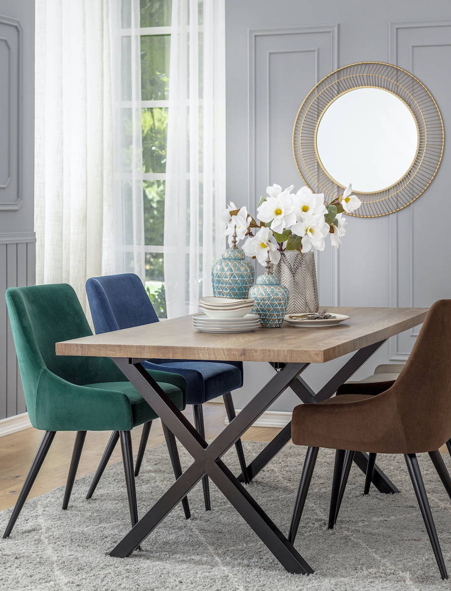 Comedor elegante con una mesa rectangular y 4 sillas de distintos colores y tapiz velvet.