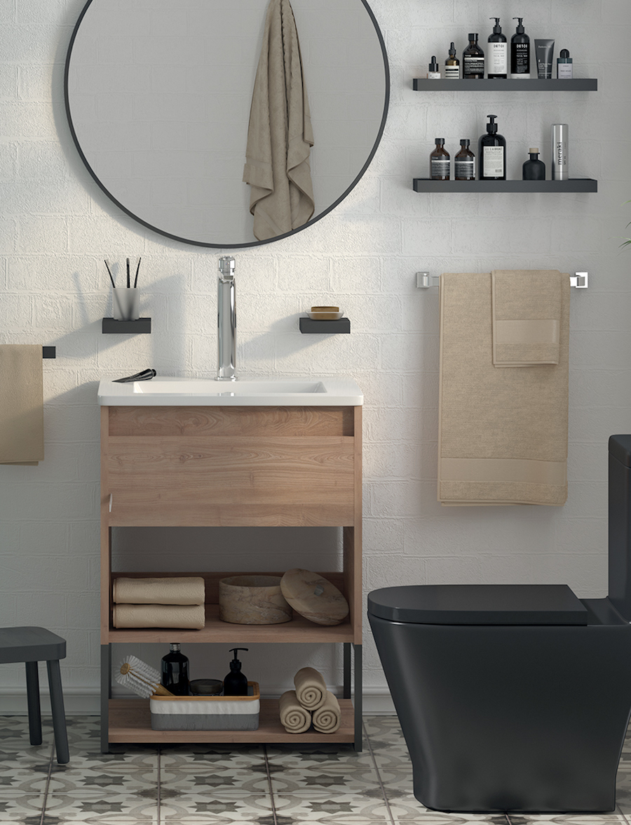Baño de estilo industrial con inodoro negro, espejo redondo con marco negro y un mueble vanitorio de madera con patas negras y lavamanos blanco.