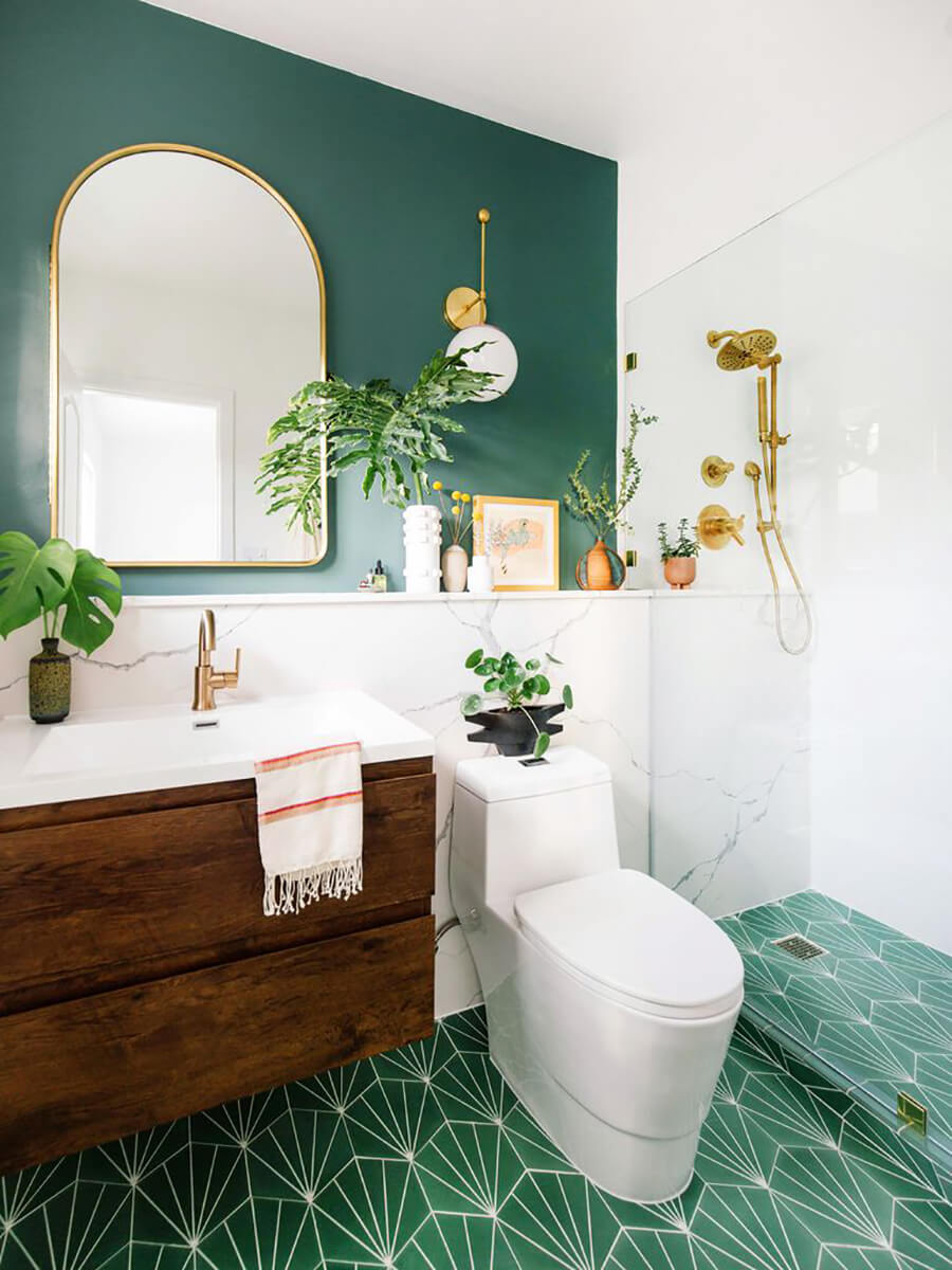 Un baño moderno con decoración para baños de estilo vintage moderno, con toques dorado y plantas que combinan con el muro y piso verde